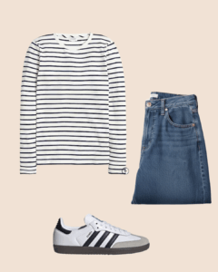 Flat lay of a casual outfit featuring a white and navy striped long-sleeve shirt, blue jeans, and white Adidas Samba sneakers on a beige background.